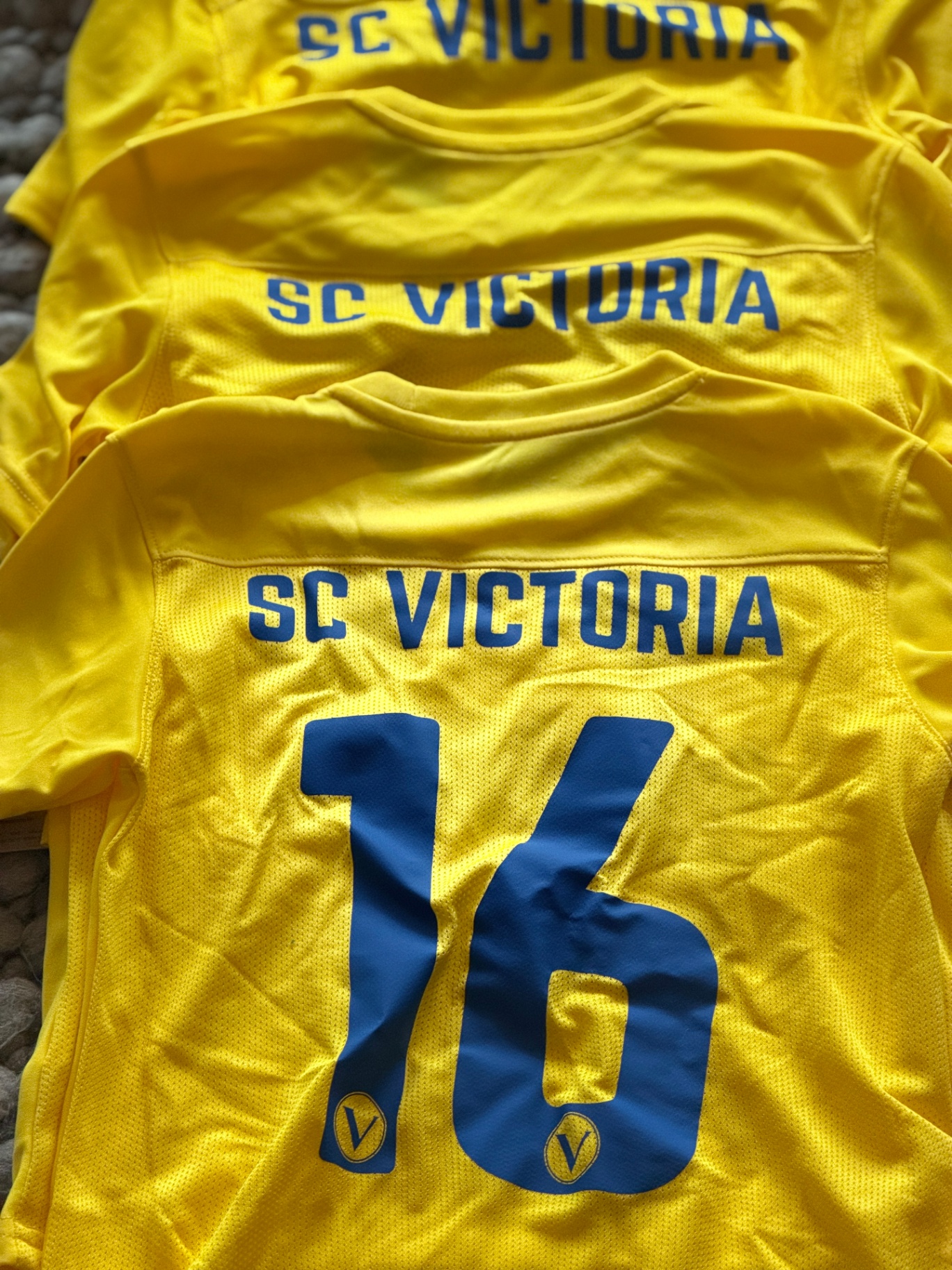 Gelbe SC Victoria Hamburg Trikots mit blauem Vereinsschriftzug